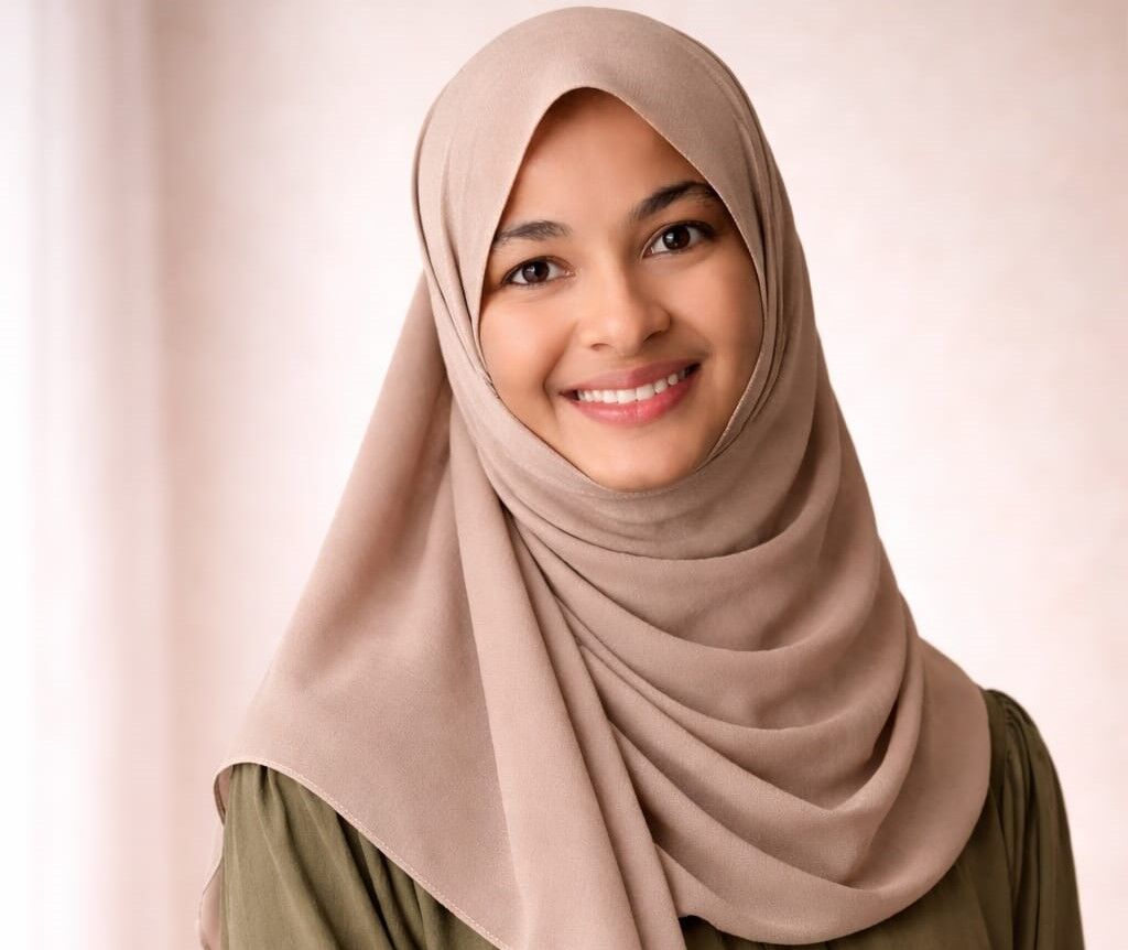 Naila Nazir - Secretarial Diploma Success Story Naila Nazir, Pitman Training Kenya Secretarial Diploma graduate, smiling in an olive green top and beige headscarf